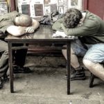 two guys sleeping on a table