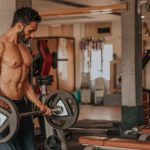 lean muscular man doing arm curls